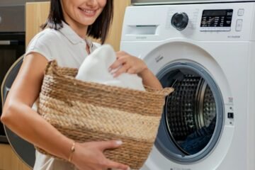 Woman holding a laundry basket near a washing machine