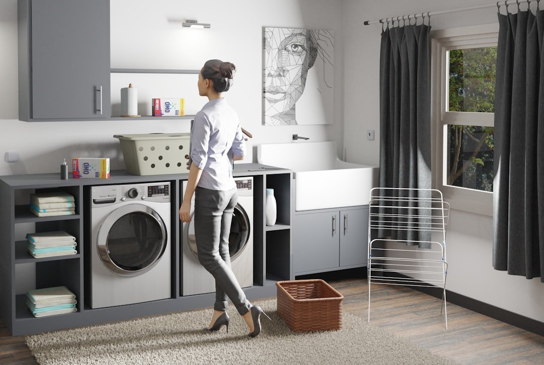 Woman standing in a laundry room next to a washer and dryer